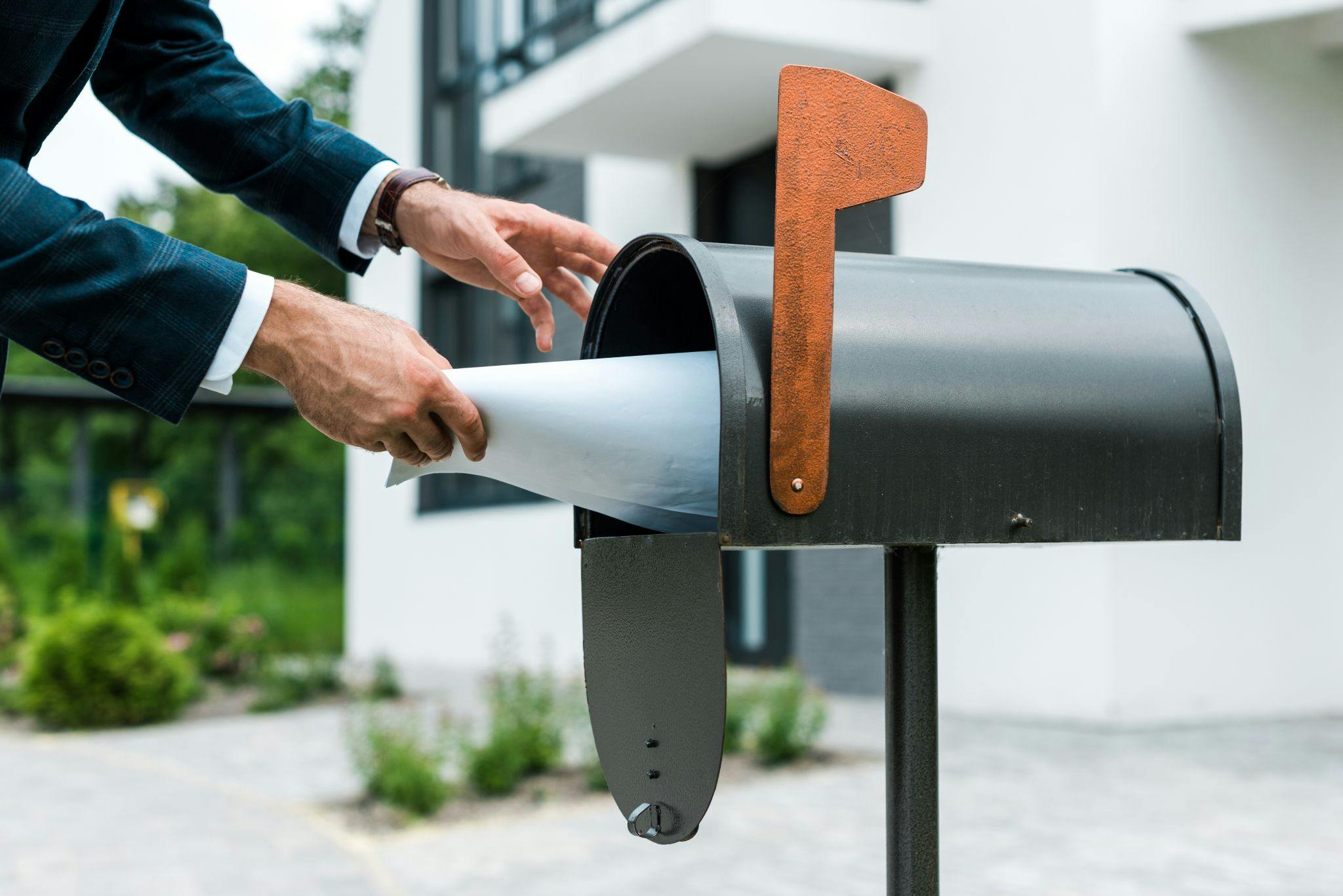 man putting package in mailbox